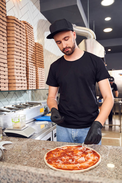 Pizzaiolo with beard making a Pizza - Foto, afbeelding