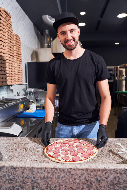 Pizzaiolo with beard making a Pizza - Foto, afbeelding