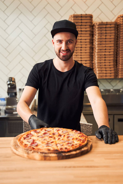 Pizzaiolo with fresh backed pizza - Fotoğraf, Görsel