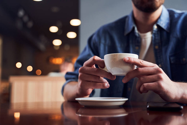 Cropped image of man with beard drinking coffee - Foto, imagen