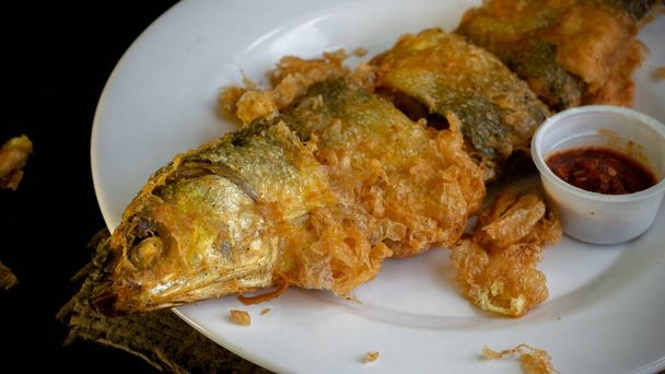 Bandeng Presto Goreng. Pesce latte fritto servito con contorni tradizionali - Foto, immagini