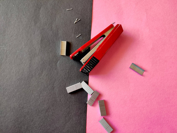 Draufsicht der roten Farbe Hefter und Stapel von Heftstiften isoliert auf rosa Hintergrund - Foto, Bild