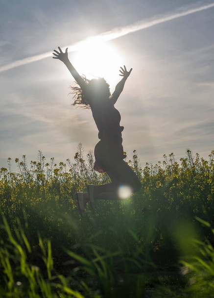 young woman cheering in rape field - Photo, Image