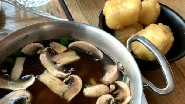 Gorąca japońska zupa z grzybami, makaronem i tofu w metalowej patelni. 4K - Materiał filmowy, wideo