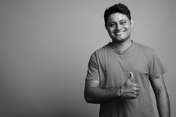 Estudio de un joven indio con camisa sobre fondo gris en blanco y negro - Foto, Imagen