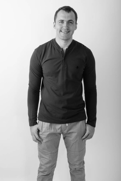 Studio shot of young muscular man against white background in black and white - Foto, Imagen