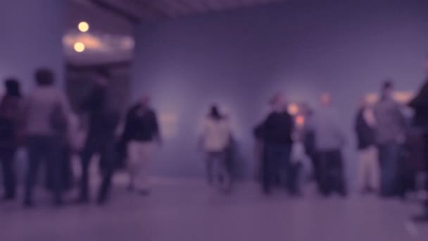 Widok ludzi spacerujących podczas wizyty w galerii sztuki. Tło z celowym efektem rozmycia. 4K - Materiał filmowy, wideo