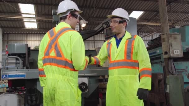 Tehdastyöntekijät kädenpuristus tiimin jäsenen kanssa tehtaalla - Materiaali, video