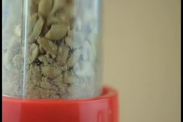 Erdnüsse werden in einem Mixer gemahlen. Nahaufnahme - Filmmaterial, Video