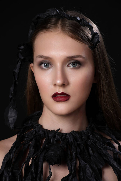 Creative art fashion look, young model whit black paper wardrobe, isolated on black - Photo, Image