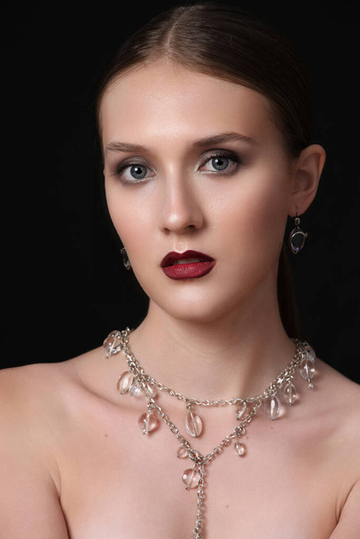 Fashion beauty model, professional makeup and beautiful beads with crystals, posing in studio, isolated on black - Foto, Imagem