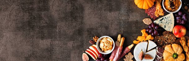 Autumn charcuterie corner border against a dark stone banner background. Selection of cheese and meat appetizers. Copy space. - Photo, Image