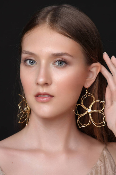 Pretty female trying on earrings. Putting on earrings. Fashion, style - Foto, Imagen