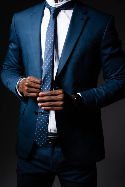 A man in a business suit straightens his tie around his neck - Foto, Bild