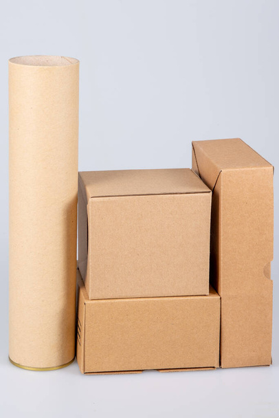beaucoup de carton brun boîte d'emballage de taille différente à expédier et tube sur un fond blanc - Photo, image