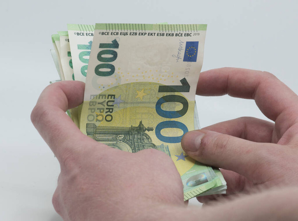 tenencia de billetes verdes de cien euros en la mano; moneda de la UE - Foto, Imagen