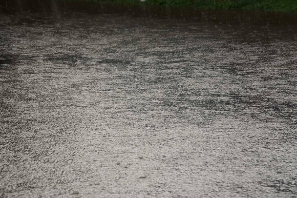 λακκούβες βροχής στο έδαφος, έντονες βροχοπτώσεις την εποχή των βροχών - Φωτογραφία, εικόνα