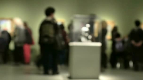 Sanat galerisi ziyareti sırasında yürüyen insanların görüntüsü. Kasıtlı olarak bulanık etki gösteren bir arka plan. 4K - Video, Çekim