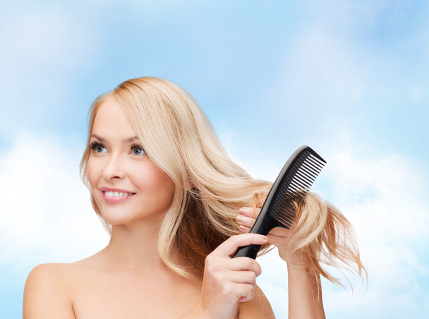 Smiling woman with hair brush - Фото, изображение