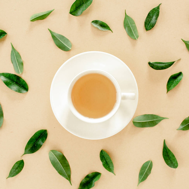 Cup of fresh green tea with tea leaves. Flat lay, top view. Tea concept - Фото, изображение