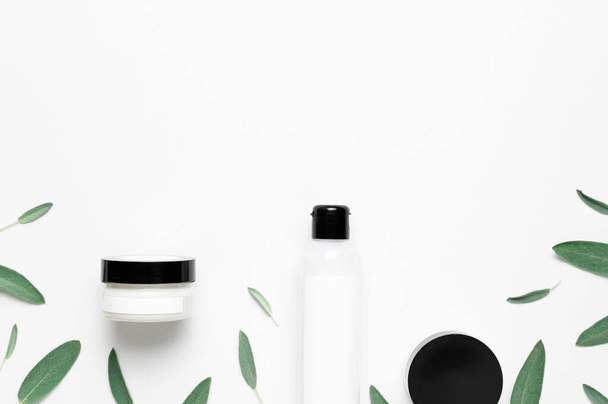 Cosmetics SPA branding mock-up. Natural Beauty organic product concept. Cosmetic containers with cream and lotion, herbal sage leaves on white background flat lay top view. Blank label for branding. - Photo, Image