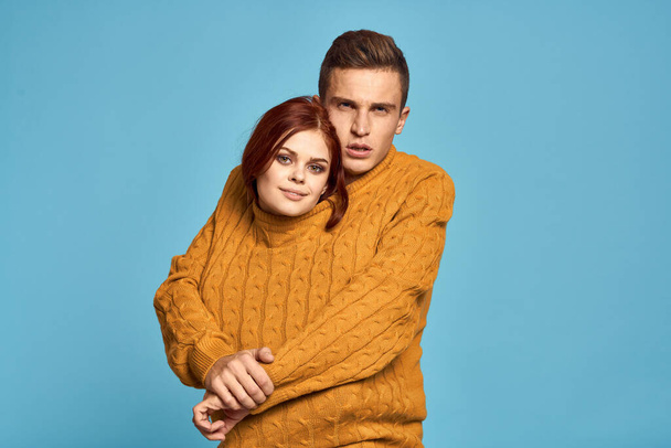 couple in love in yellow sweater posing against blue background cropped view Copy Space - Valokuva, kuva