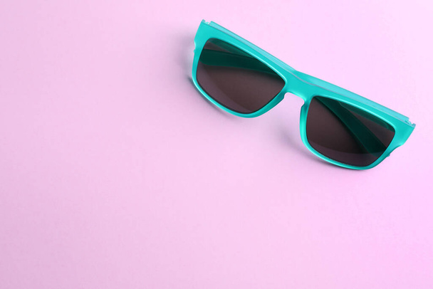 Stylish sunglasses on light violet background, top view. Space for text - Foto, afbeelding