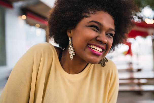 Close-up of a beautiful afro american latin woman smiling and spending nice time at the coffee shop.  - Foto, immagini