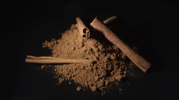 Sticks and powder cinnamon pile rotating in black background - Footage, Video