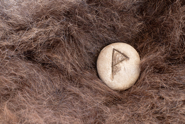 Wunjo Nordic stone rune on fur. Letter Wyn of the Viking alphabet. - Photo, Image