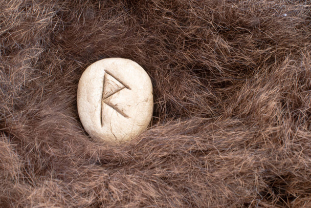 Райдо или Райдо Нордическая каменная руна на мехе. Письмо Раэда о викинге. - Фото, изображение