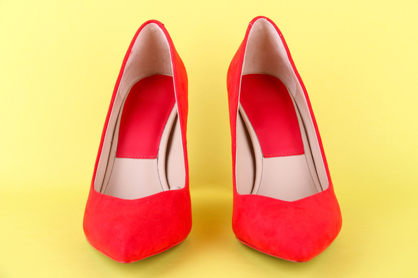 Beautiful red female shoes, on yellow background - Фото, зображення