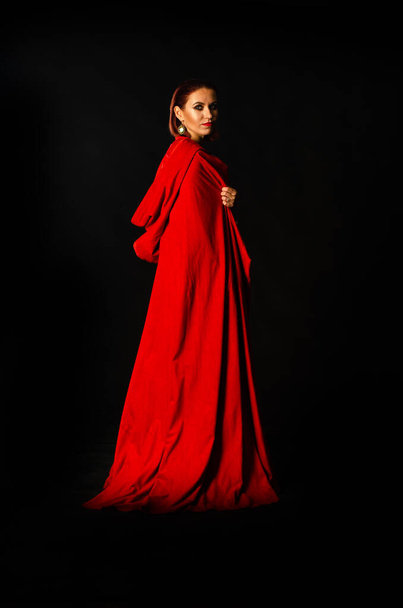 krásná žena v červeném plášti ve studiu. Žena Červená Karkulka. Dramatické a fantastické natáčení, módní tón. Jako princezna. - Fotografie, Obrázek