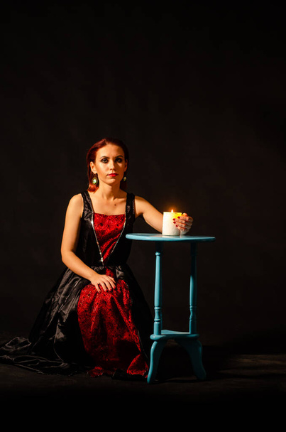 Geheimnisvolle magische Nahaufnahme, Frau, die in Isolation über brennende Kerzen auf schwarzem Hintergrund zaubert. Das Konzept der Vorhersage, des Hellsehens und der Wahrsagerei. - Foto, Bild