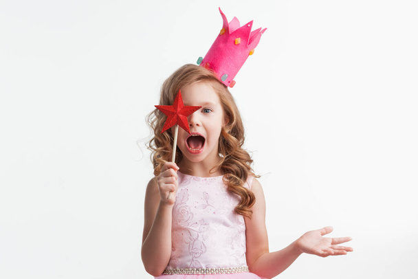 Beautiful little candy princess girl in crown holding star shaped magic wand putting spell isolated on white - Fotoğraf, Görsel