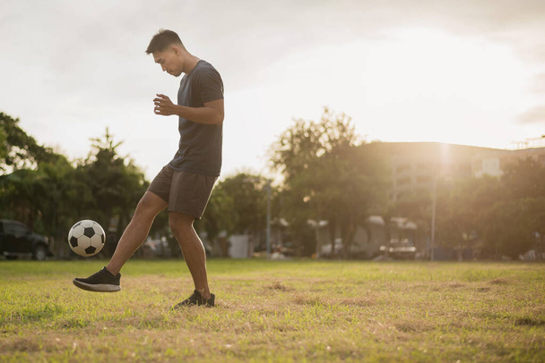 Man playing football at green field. asian soccer player playing football. - 写真・画像