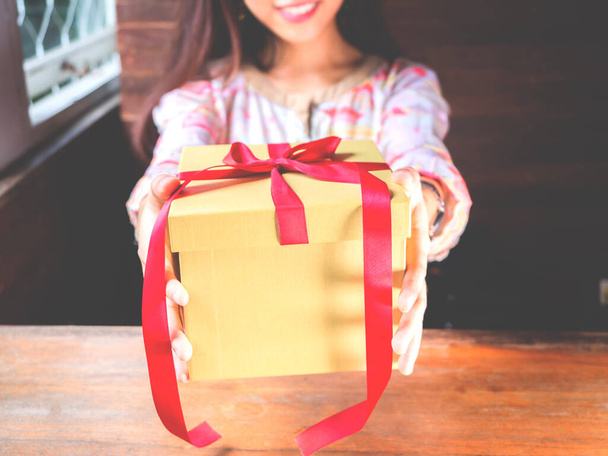 Красная лента подарок или подарочная коробка в руках женщины. Рождество или день рождения подарок и День благодарения, больше дать больше получить концепцию. люди, проявляющие любовь в день святого Валентина - Фото, изображение