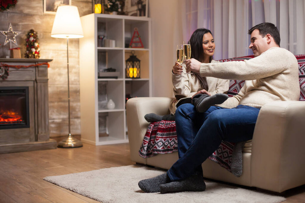 Coppia innamorata seduta sul divano a festeggiare il Natale - Foto, immagini