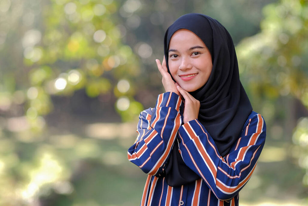 Portrait of cute Malay Asian lady wearing hijab outdoor. - Photo, Image