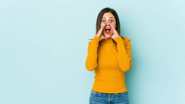 Young woman isolated on blue background shouting excited to front. - Foto, Imagem