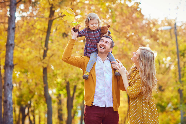 秋に公園で遊ぶ娘の両親 - 写真・画像