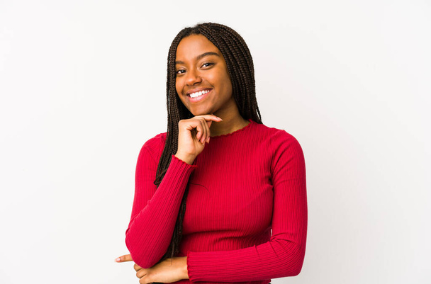 Giovane donna afroamericana isolata sorridente felice e sicura di sé, toccando il mento con mano. - Foto, immagini