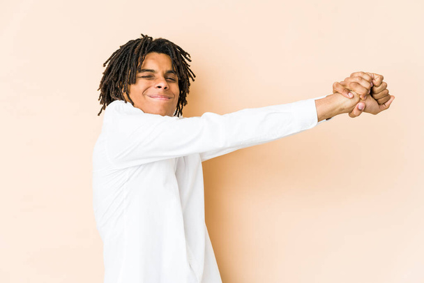 Fiatal afro-amerikai raszta férfi kinyújtott karokkal, nyugodt pozícióban. - Fotó, kép