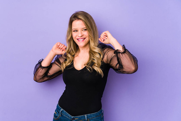 Young caucasian woman isolated on purple background celebrating a special day, jumps and raise arms with energy. - Photo, Image
