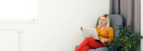 Зображення щасливої жінки, використовуючи ноутбук вдома
 - Фото, зображення