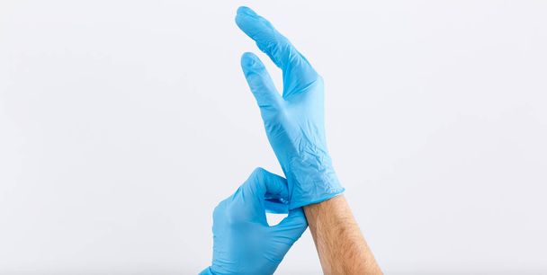 Doctor putting on protective gloves, isolated on white - Photo, Image