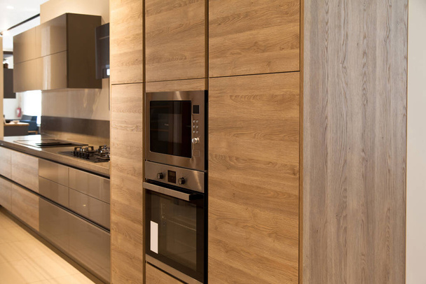 Interior de lujosos equipos de cocina modernos, armarios grises y de roble - Foto, imagen