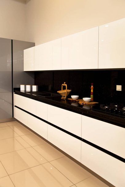 Belső tér luxus modern konyha, fehér szürke szekrények és fekete gránit - Fotó, kép