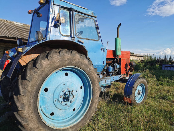 Old Tractor blue parking I.in iackyard In Summer Sunny Day. Special Agricultural Equipment. - Photo, Image