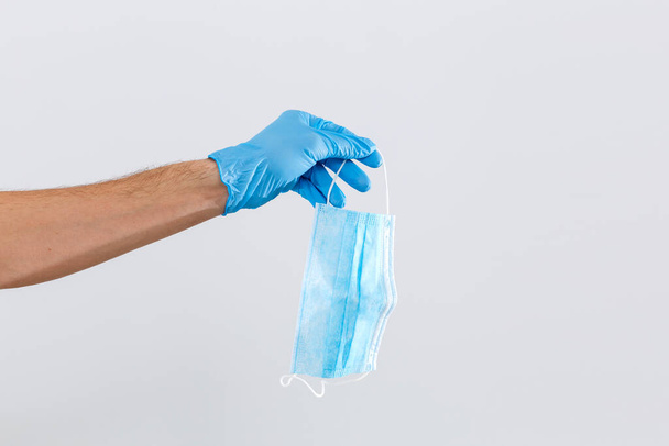 крупним планом рука лікаря з медичною маскою для захисту від інфекції
 - Фото, зображення